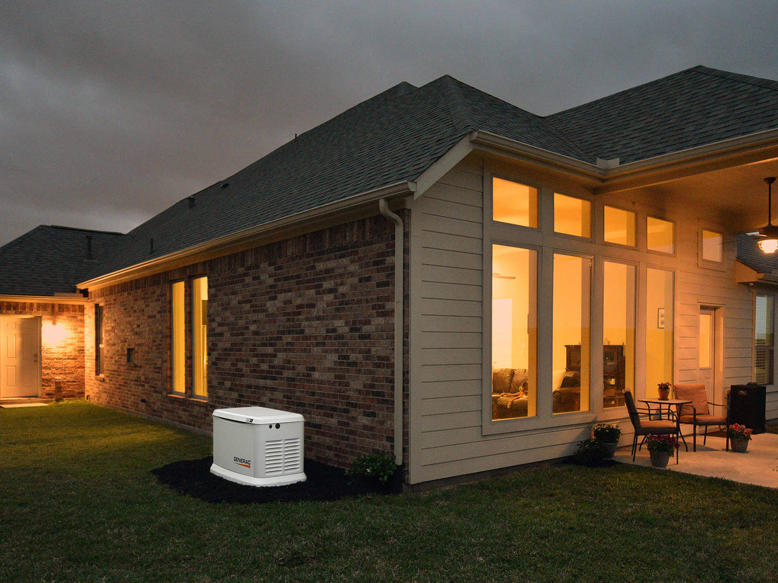 generac-home-standby-generator-dusk-backyard-house-lights-on-2-1